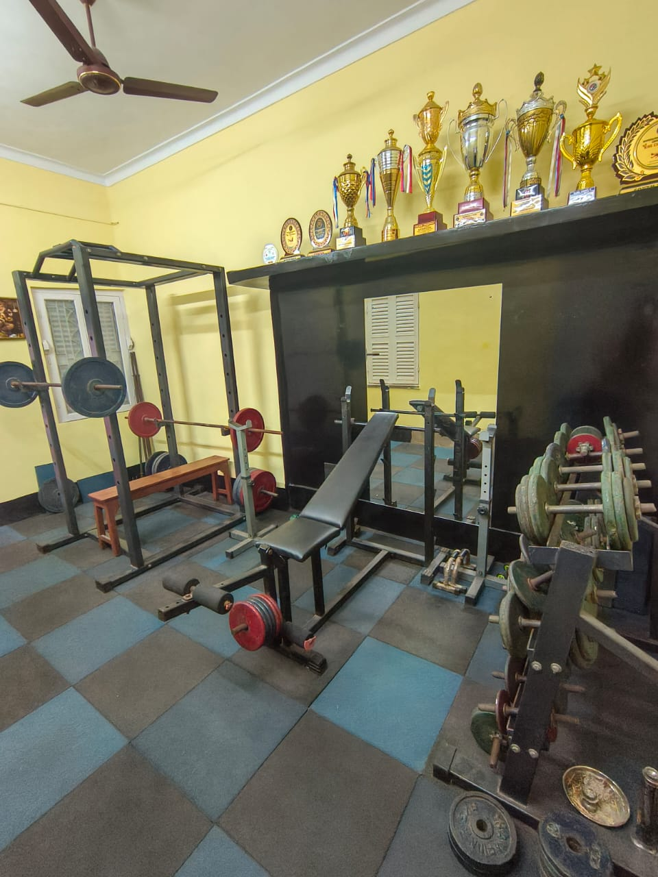 Strength and conditioning room with trophies at Golds Combat Fight